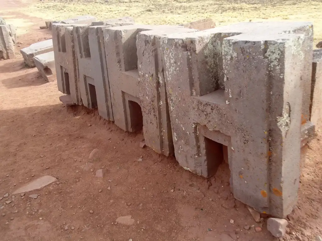 Precisely carved H-shaped andesite stone blocks at the Puma Punku archaeological site in Bolivia, showcasing advanced ancient architecture