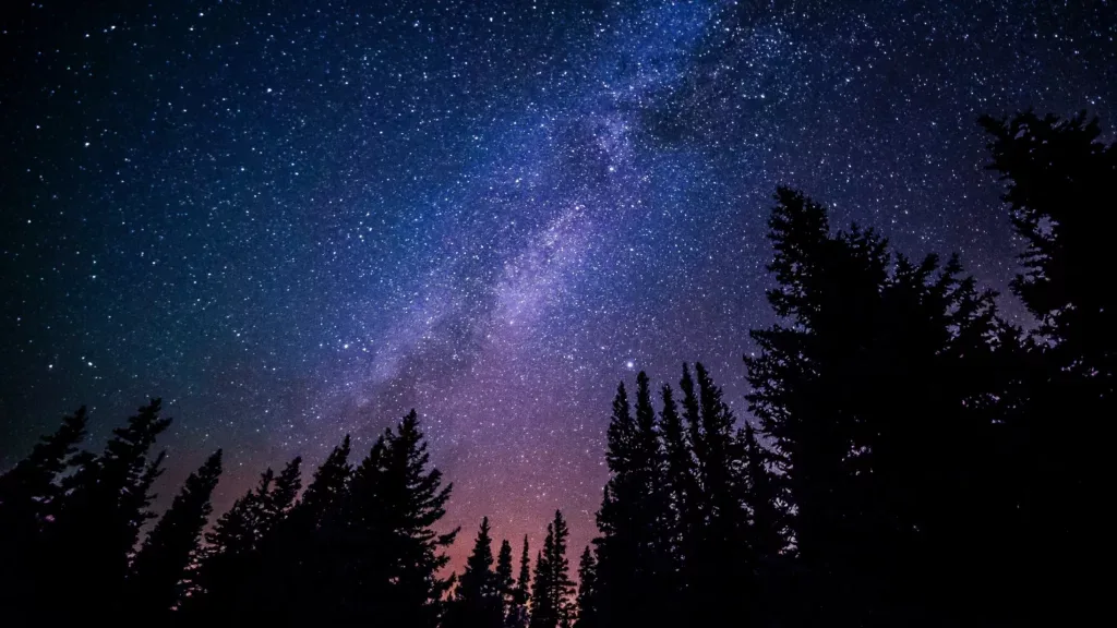 The Milky Way galaxy stretches across the night sky in a magnificent spiral of stars and cosmic dust